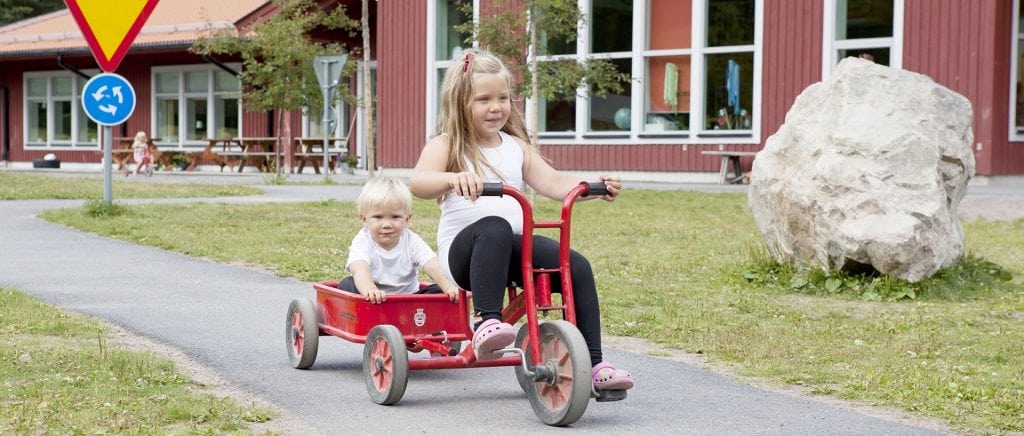 Barn på trehjuling på cykelväg