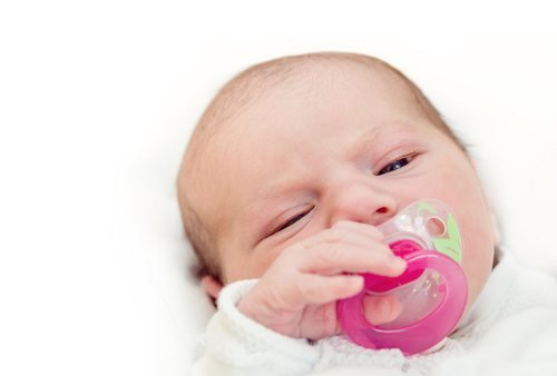 Bebis med napp i munnen