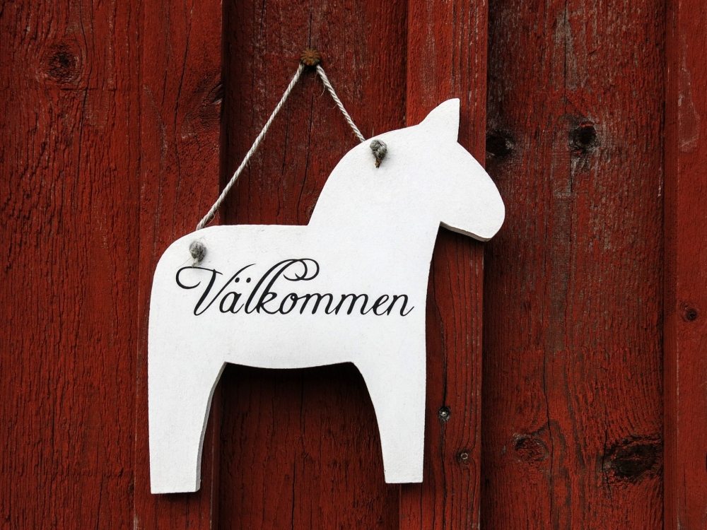 Foto på en välkomstskylt utformad som en dalahäst