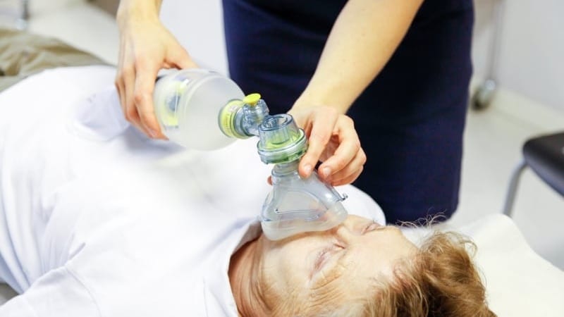 Person med andningsbesvär får hjälp.